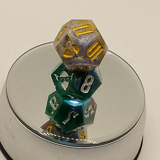 Three polyhedral dice with different colors and numbers inside a reflective container.