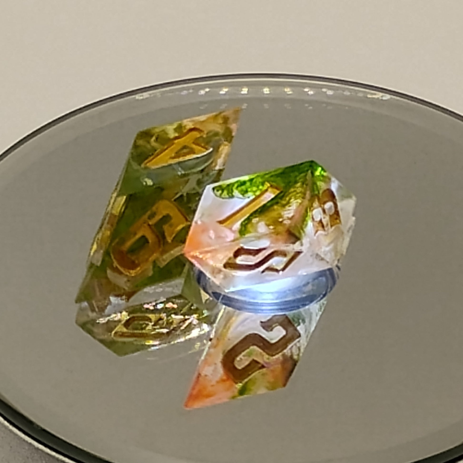 Colorful transparent dice with letter 'B' on a reflective surface