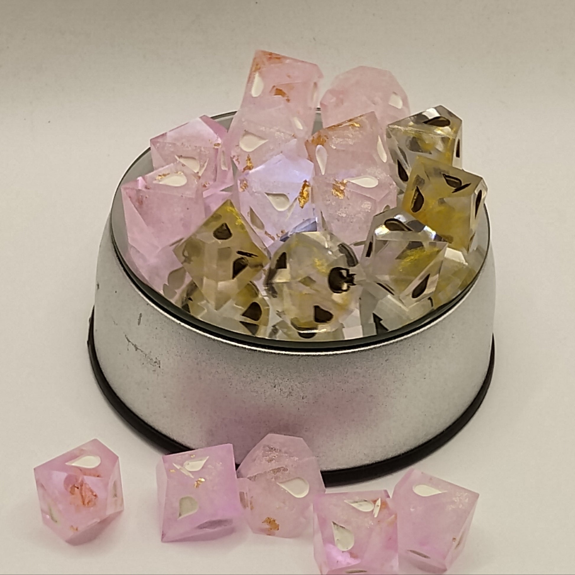 Decorative container with pink and gold square-shaped items on a beige background