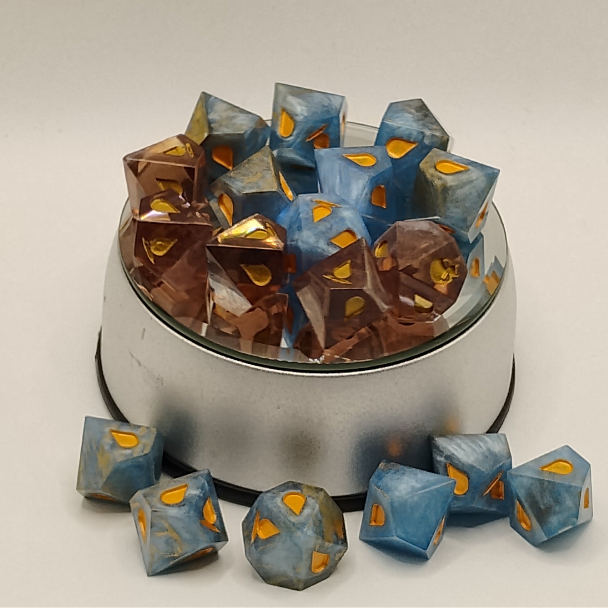 Set of polyhedral dice with blue and brown colors on a beige background