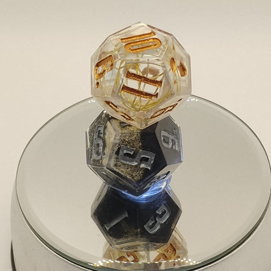 Close-up of three polyhedral dice with numbers on a reflective surface
