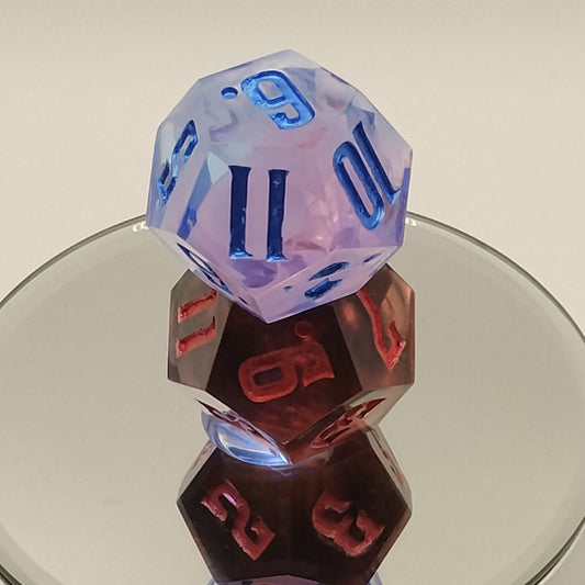 Two polyhedral dice, one pink and blue and one brown with red numbers, on a reflective surface.