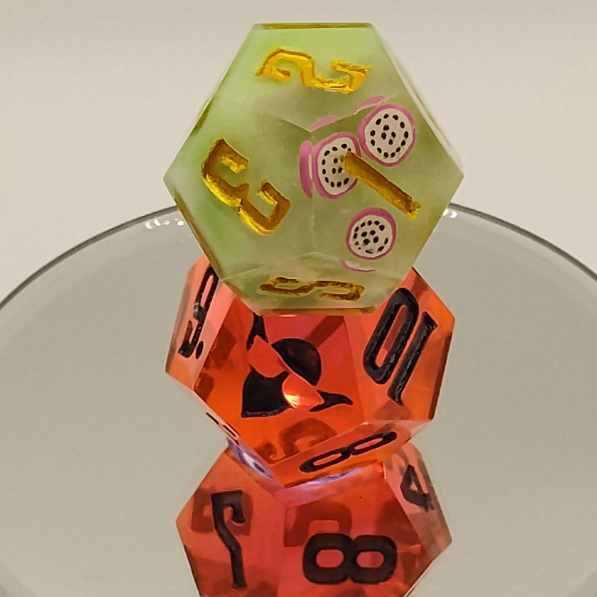 Three polyhedral dice with different numbers on a reflective surface