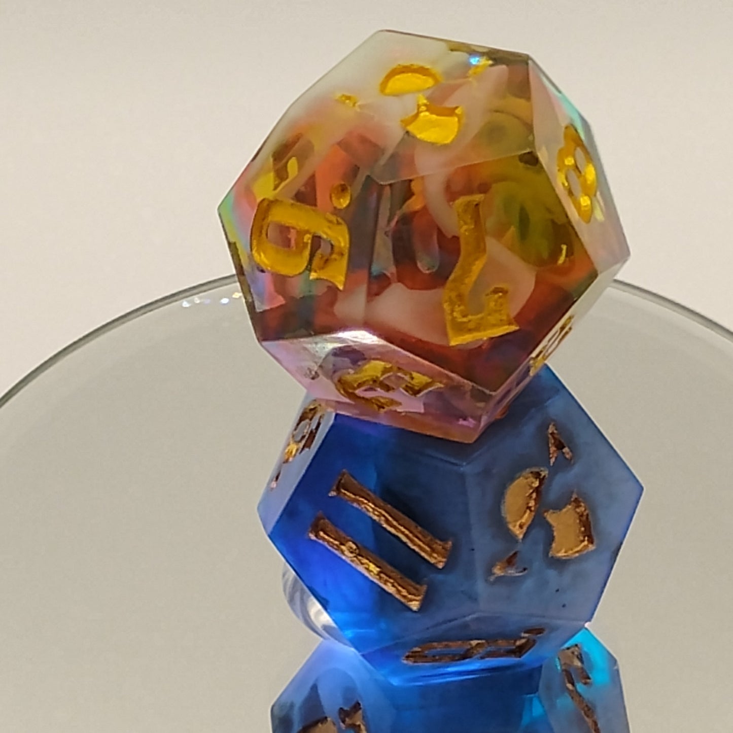Three polyhedral dice with gold numbers on a white background