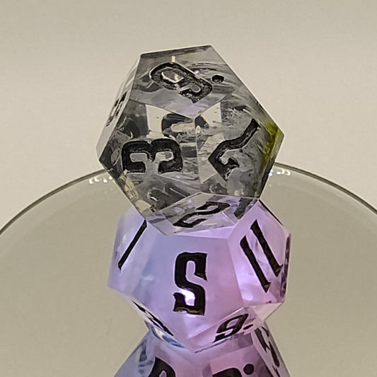 Two polyhedral dice, one clear with black numbers and one pink with black numbers, on a neutral background.