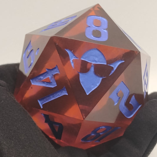 Polyhedral dice with red and blue numbers held by a person wearing a dark sweater.