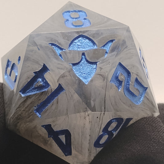 D20 polyhedral dice with blue numbers held by a gloved hand
